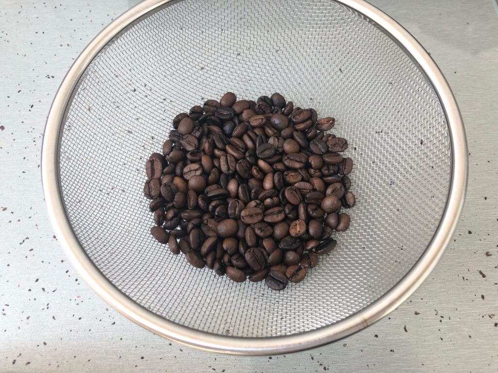焙煎したコーヒー豆をざるに移した画像