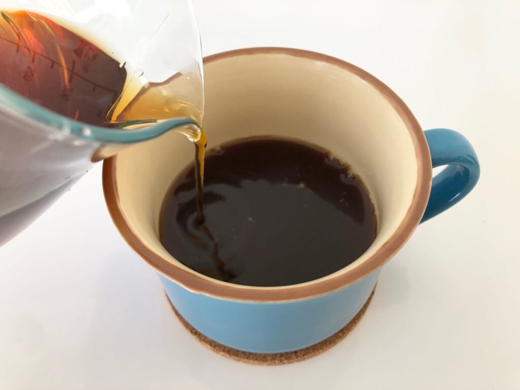 カップにコーヒー注ぐ画像
